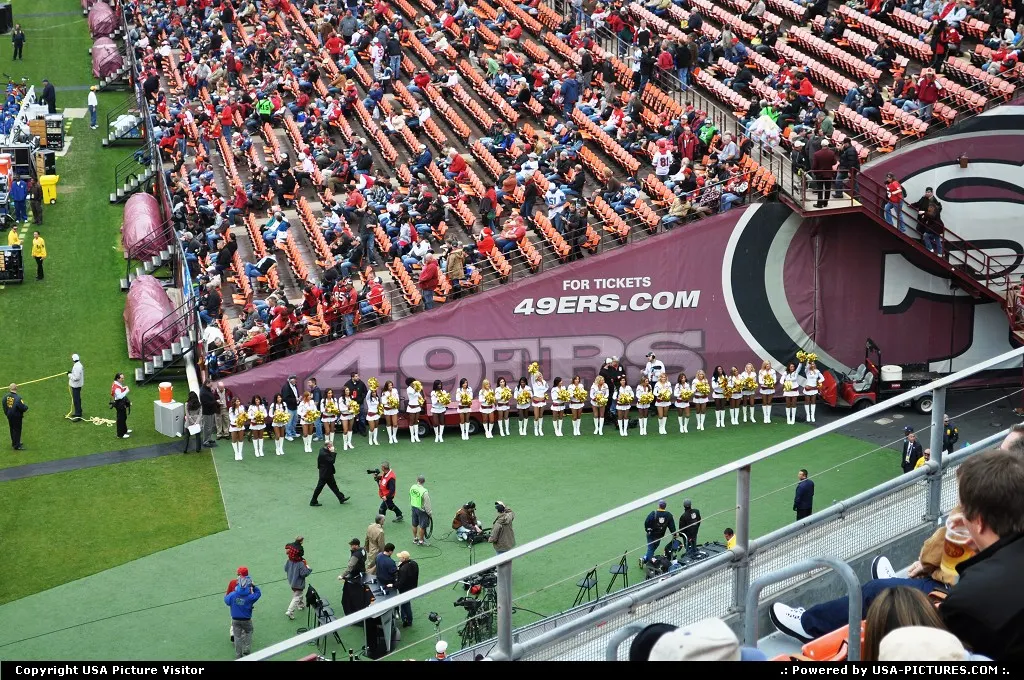 People start to seat into the stadium while cheerleader are ready for the show