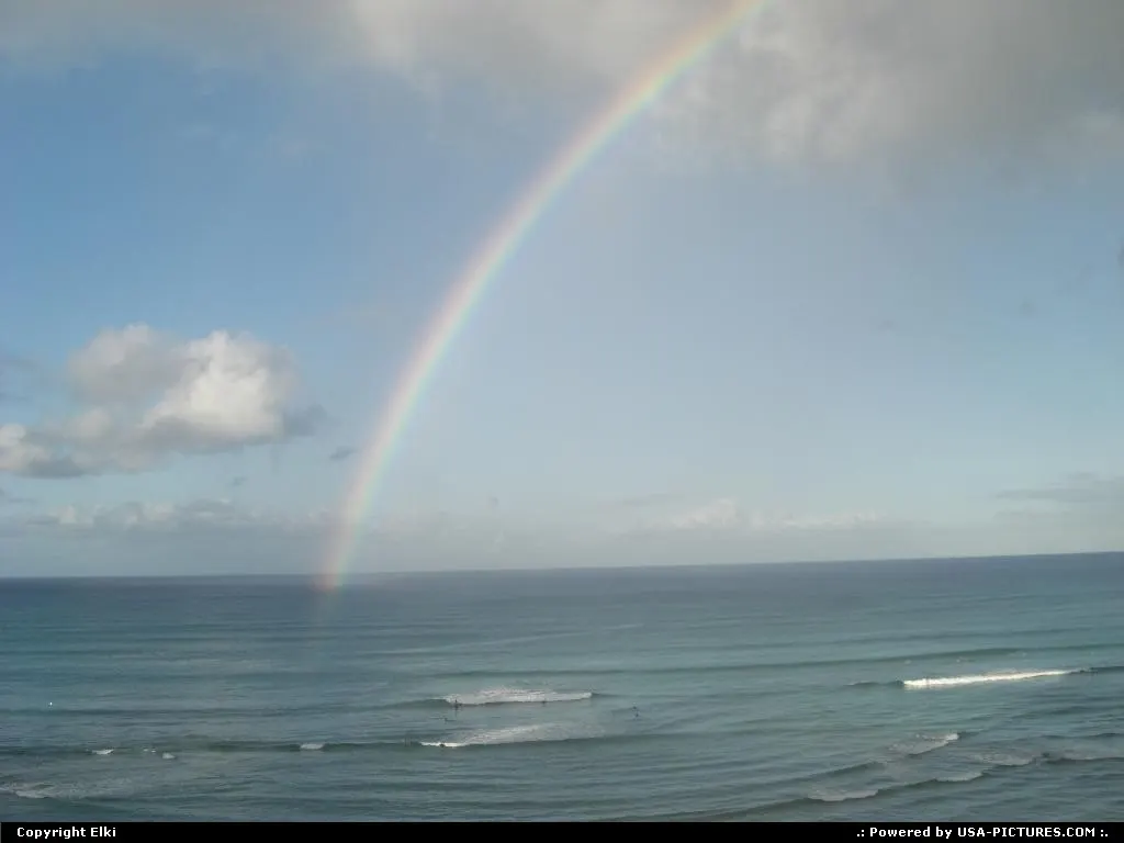 Surfing in waikiki beach under the raimbow