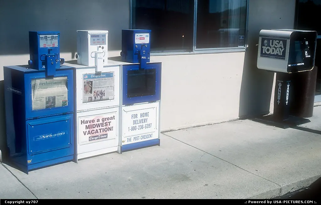 Somewhere along road 41 from Milwaukee to Oshkosh, a quartet of newspapers vending mach...
